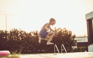 Image of a child jumping into a pool