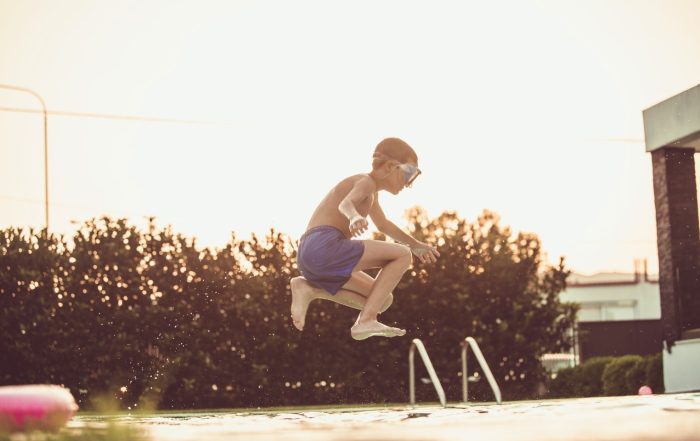 Image of a child jumping into a pool